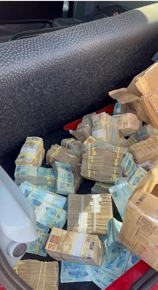 Quantia apreendida estava em bolos com notas de R$ 50, 100 e 200 no porta-malas do veículo Renault Clio, de cor vermelha.