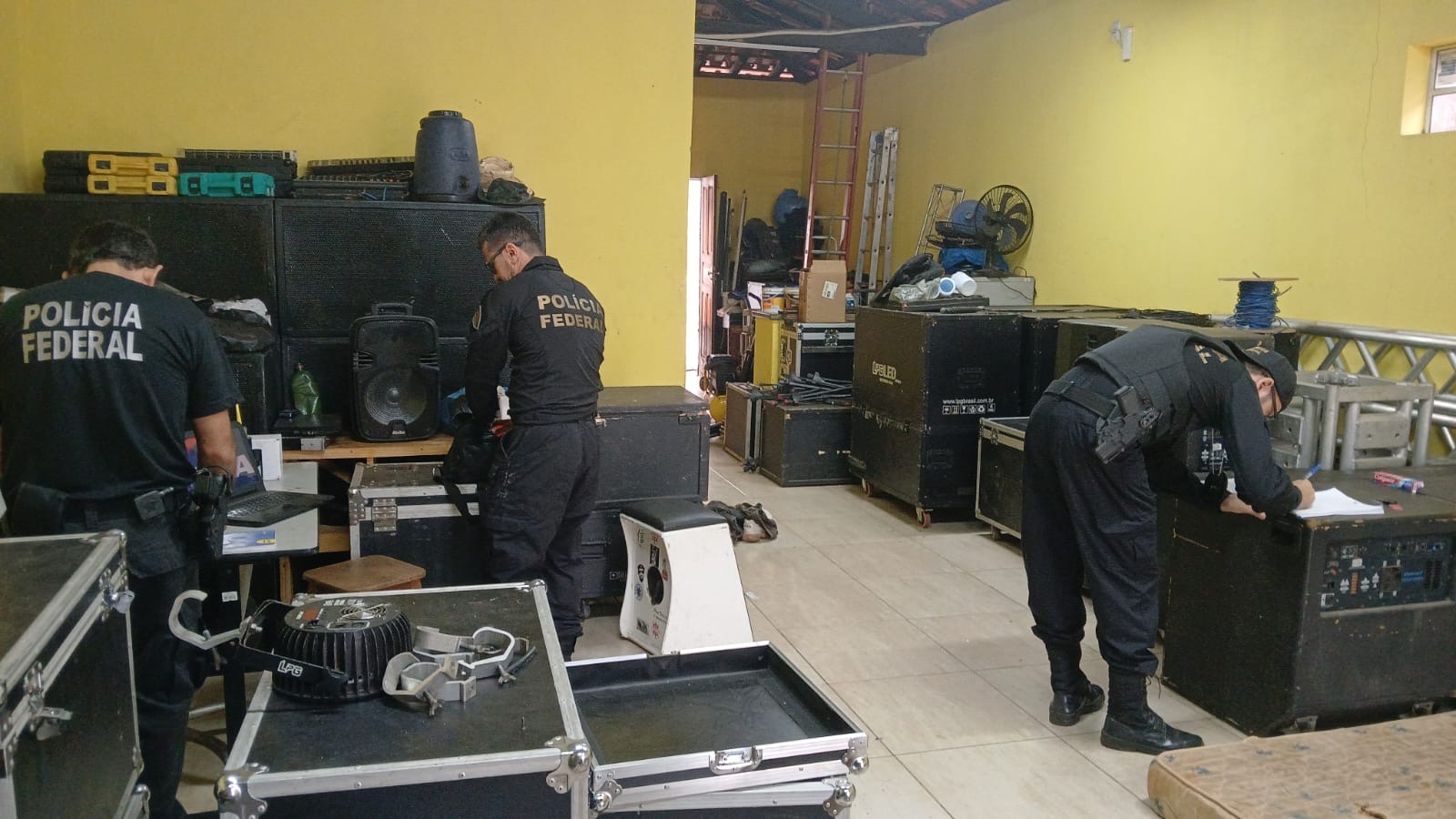 Agentes da Polícia Federal dentro da empresa de sonorizações realizando busca e apreensão.